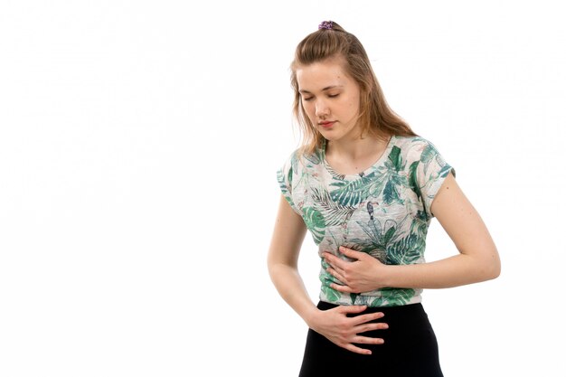 A front view young attractive lady in designed shirt and black skirt suffering from stomackache on the white