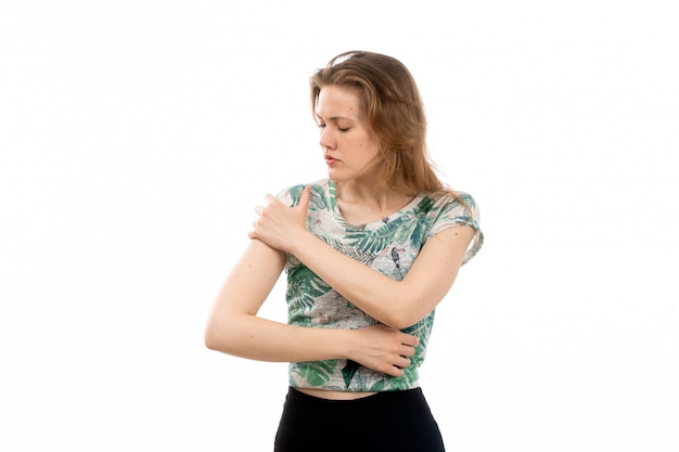 Free photo a front view young attractive lady in designed shirt and black trousers suffering from arm ache on the white