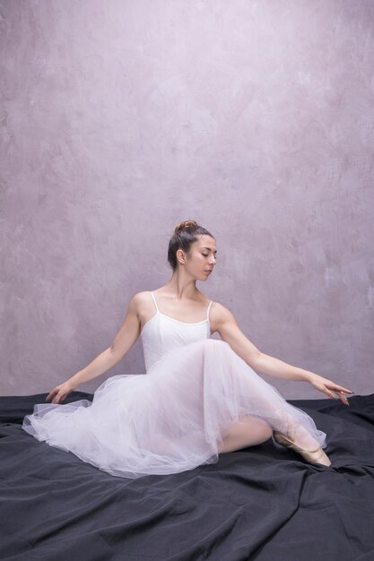 Вид спереди молодой балерины сидя