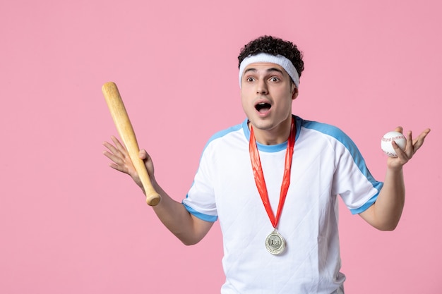 Front view young baseball player in sport clothes with medal and bat