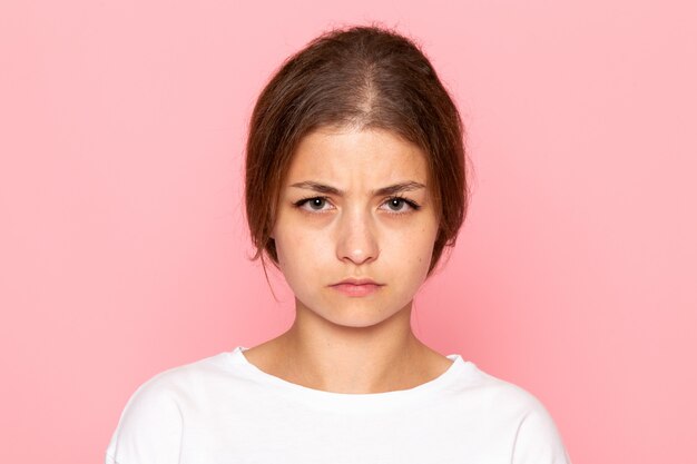 A front view young beautiful female in white shirt posing with depressed expression