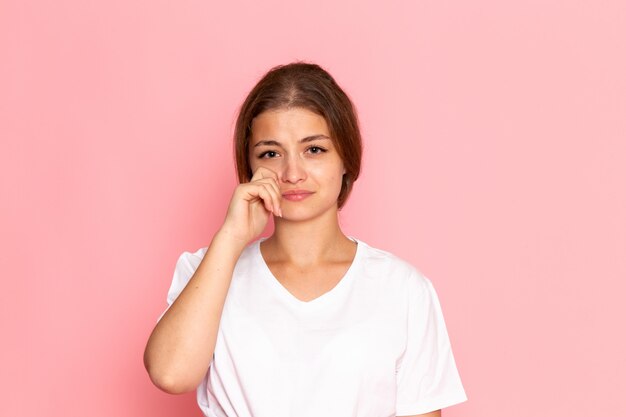 A front view young beautiful female in white shirt posing with tears in her eyes