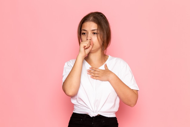 A front view young beautiful female in white shirt severely coughing
