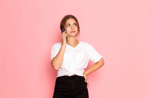 A front view young beautiful female in white shirt talking on the phone