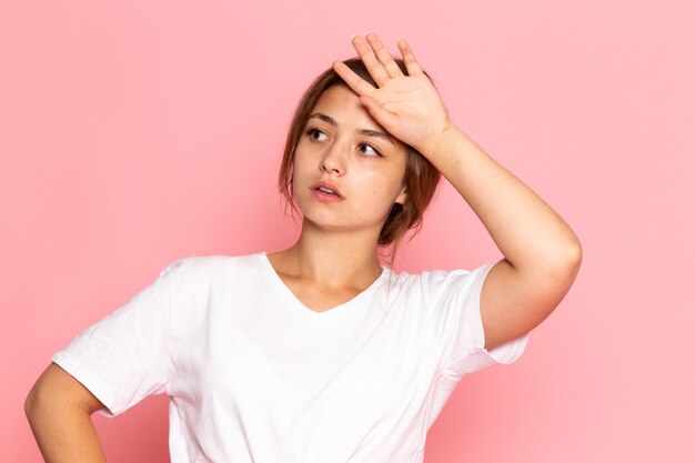 A front view young beautiful female in white shirt with posing with tired expression