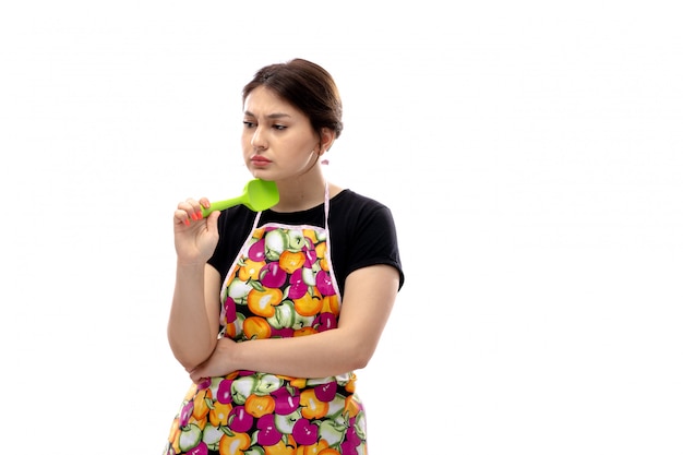 A front view young beautiful lady in black shirt and colorful cape holding green kitchen appliance thinking melancholic