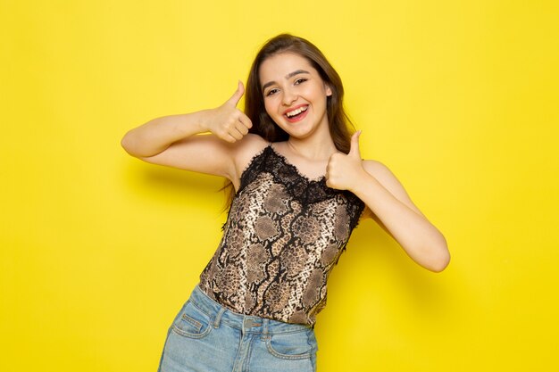 A front view young beautiful lady in brown blouse and blue jeans smiling and posing