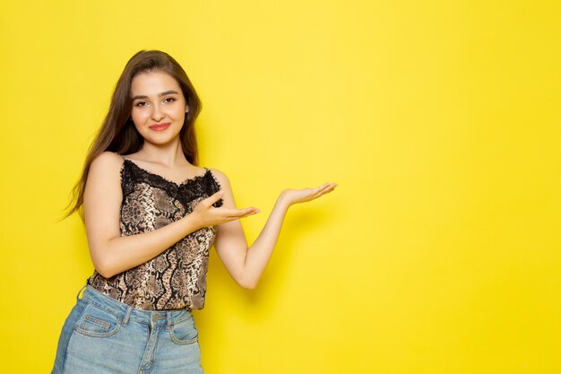 A front view young beautiful lady in brown blouse and blue jeans smiling and posing