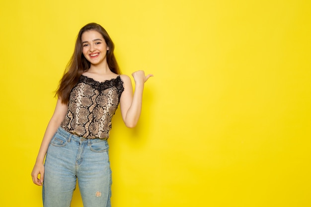 A front view young beautiful lady in brown blouse and blue jeans smiling