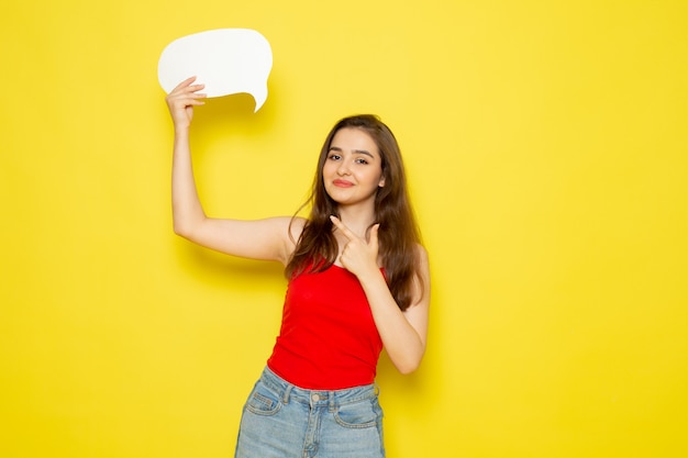 A front view young beautiful lady in red shirt and blue jeans holding white sign and smiling