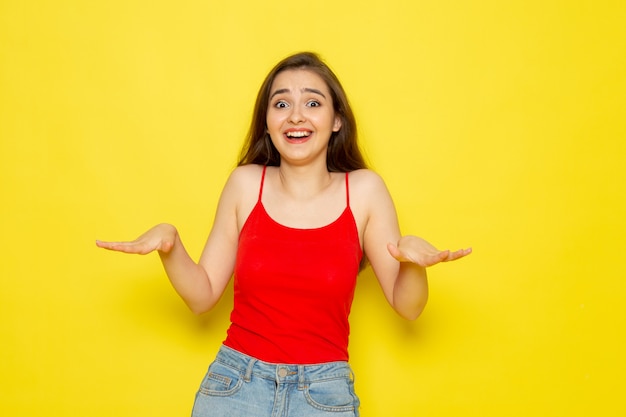 A front view young beautiful lady in red shirt and blue jeans posing