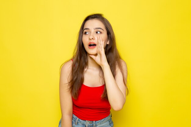 A front view young beautiful lady in red shirt and blue jeans posing