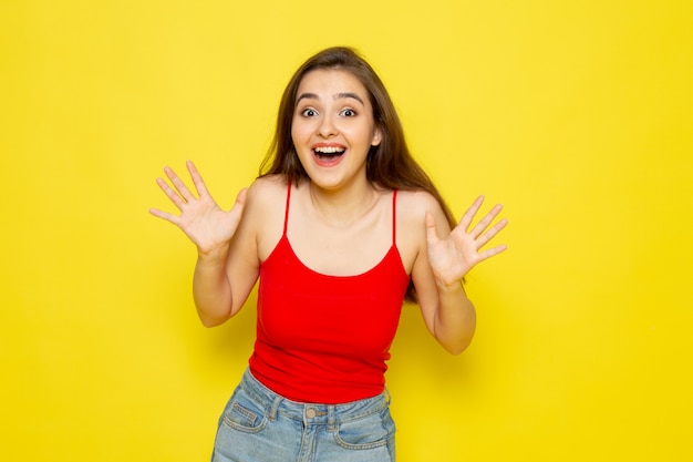 A front view young beautiful lady in red shirt and blue jeans smiling