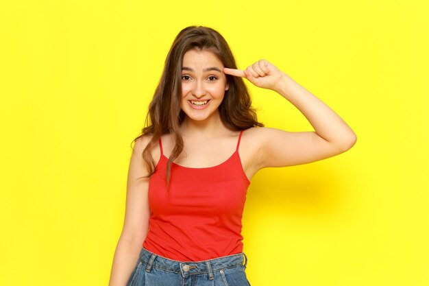 A front view young beautiful lady in red shirt and blue jeans smiling