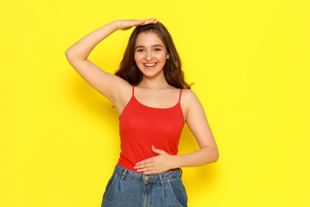 A front view young beautiful lady in red shirt and blue jeans smiling