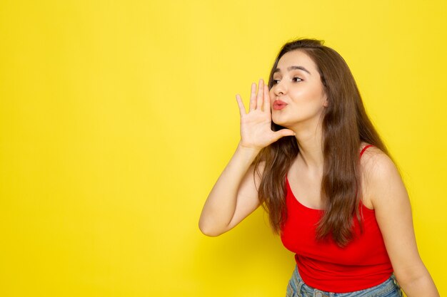 A front view young beautiful lady in red shirt and blue jeans whispering