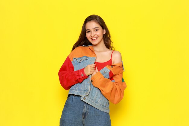 A front view young beautiful lady in red shirt coat and blue jeans with smiling expression