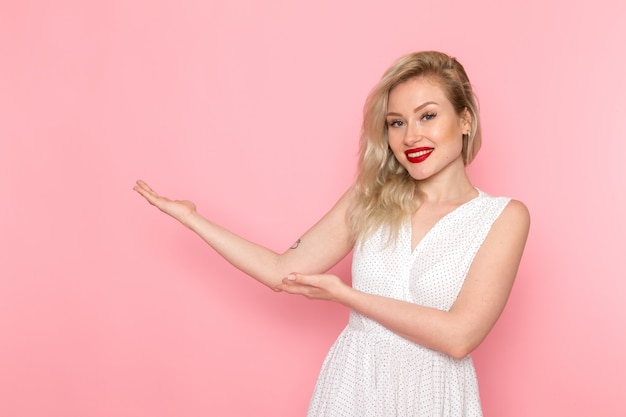 A front view young beautiful lady in white dress posing with smile on her face