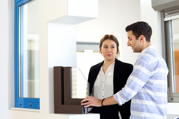 A front view young beautiful lady in white shirt dark jacket black trousers along with young man discussing work during daytime building job activity