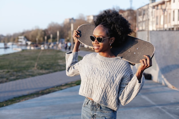 Free photo front view young beautiful woman holding a skateboard