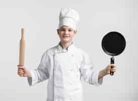 Free photo front view young boy dressed up as chef holding tools