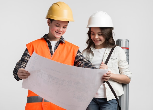 Front view young boy and girl reading construction plan