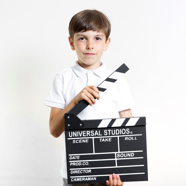 Front view young boy holding clapperboard