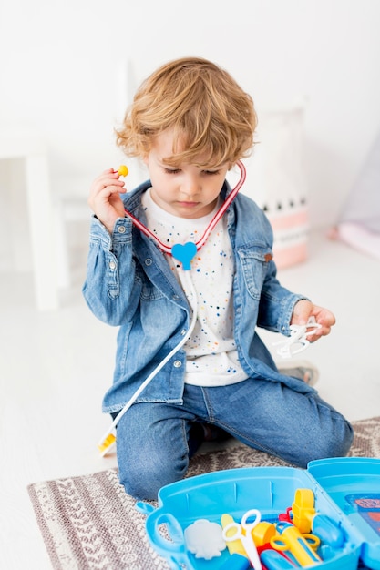 Front view of young boy playing with stethoscope