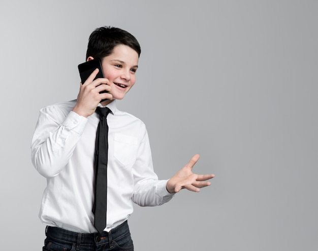 Free photo front view young boy talking on mobile phone