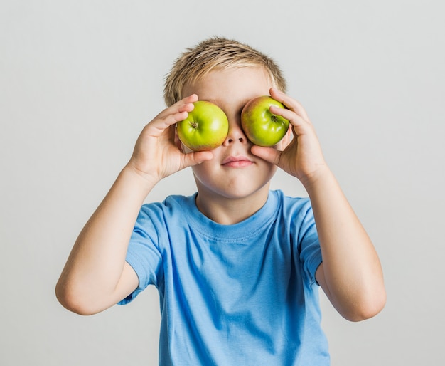 Free photo front view young boy with apples