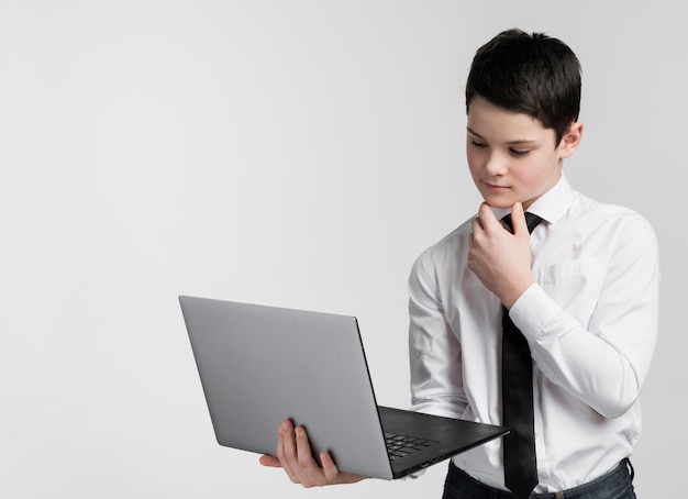 Free photo front view young boy working on laptop