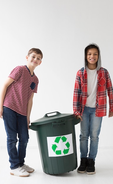 Front view young boys holding recycle bin