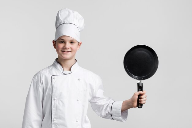 Front view young chef holding cooking pan