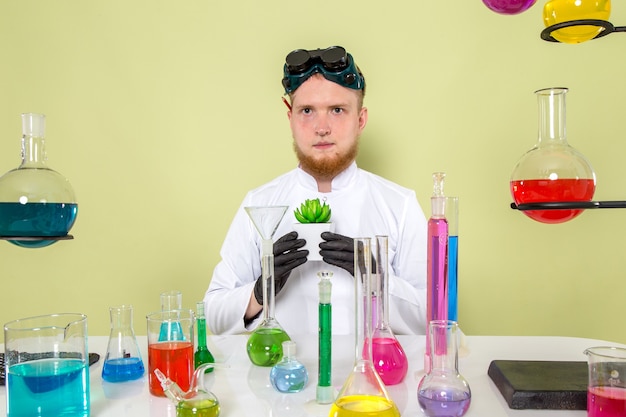 실험실에서 그의 신선한 식물을 들고 전면보기 젊은 화학자