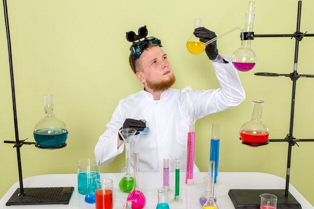 Front view young chemist researching about yellow chemical in a lab