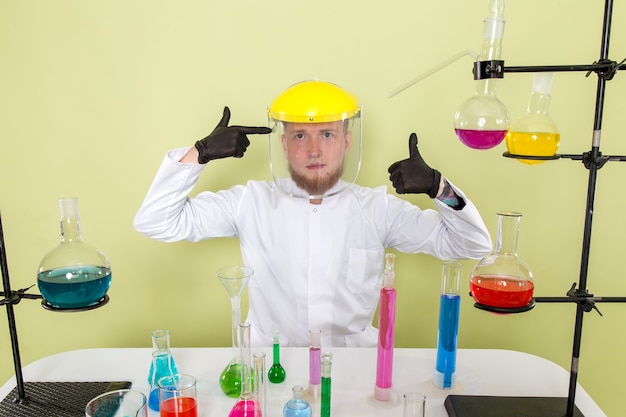 Front view young chemist shows that his protection helmet is absolutely nice