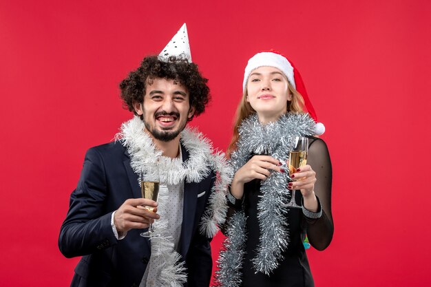 Вид спереди молодая пара празднует новый год на красном столе, праздник рождественской любви