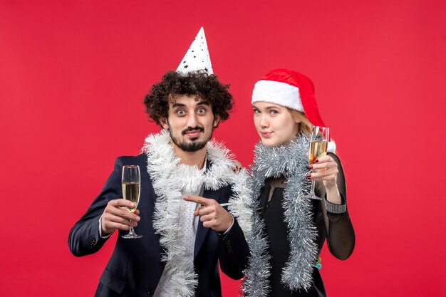 Вид спереди молодая пара празднует новый год на красном столе, праздники, рождественская любовь