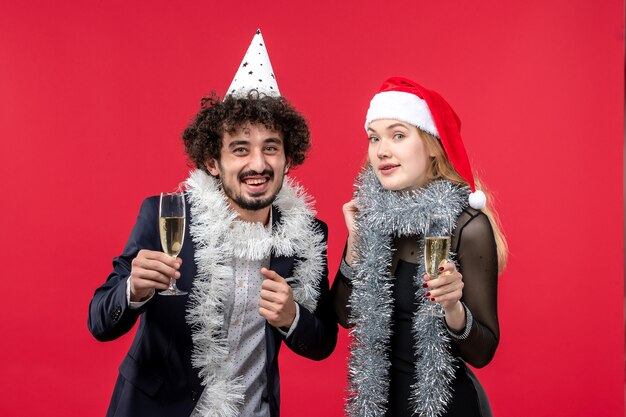 Front view young couple celebrating new year on red desk love christmas party