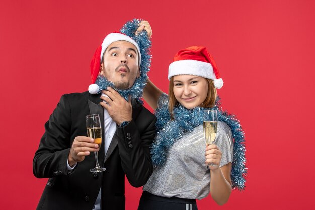 Front view young couple celebrating new year on red floor love christmas party drink