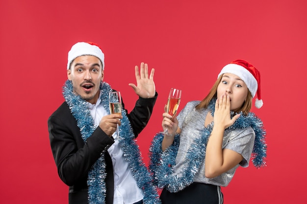 Front view young couple celebrating new year on red floor party christmas love