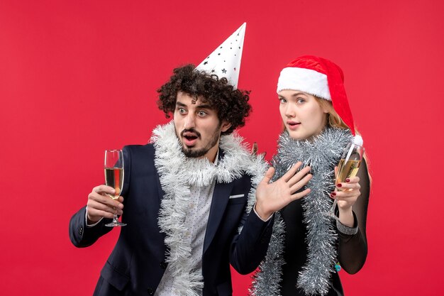 Front view young couple celebrating new year on red wall christmas love holiday