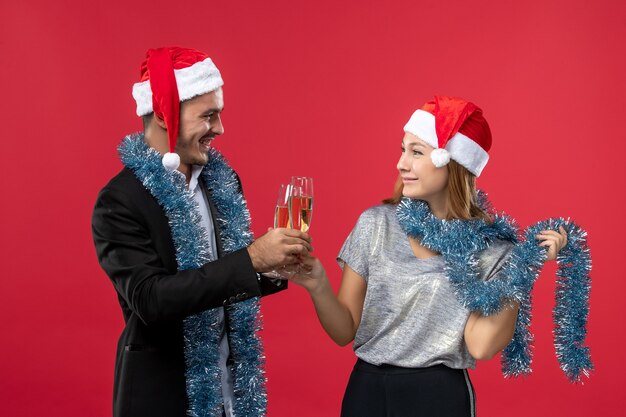 Front view young couple celebrating new year on a red wall color love christmas