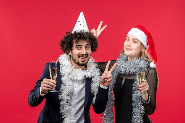 Front view young couple celebrating new year on a red wall love christmas party