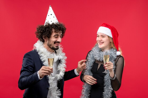 Free photo front view young couple celebrating new year on a red wall party holiday christmas love