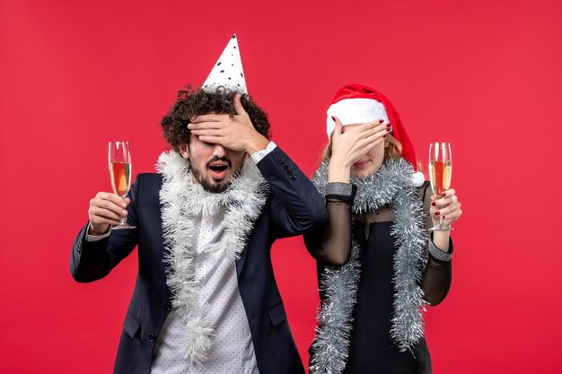 Foto gratuita giovani coppie di vista frontale che celebrano appena il nuovo anno sulla festa di natale di amore dello scrittorio rosso