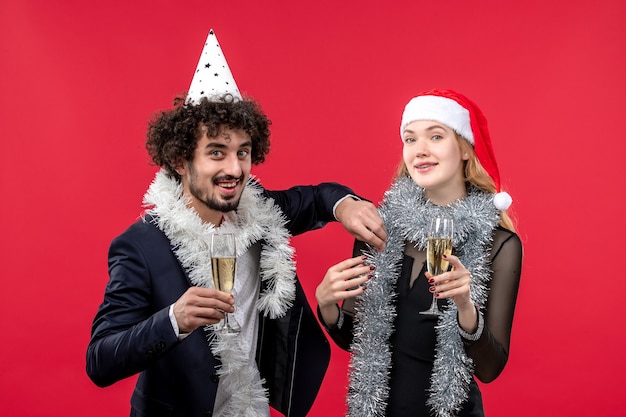 Front view young couple just celebrating new year on red desk party christmas love