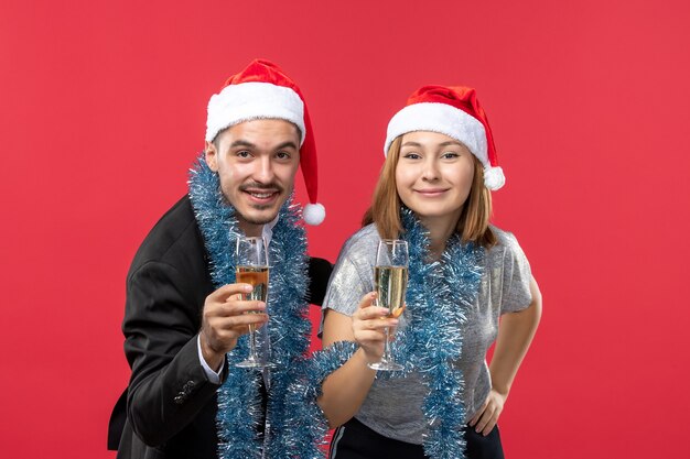 Вид спереди молодая пара просто празднует новый год на красном полу, вечеринка, любовь, рождество