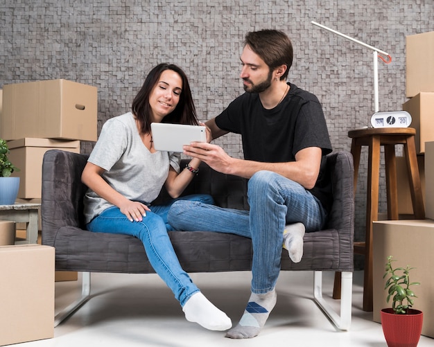 Free photo front view young couple sitting on sofa