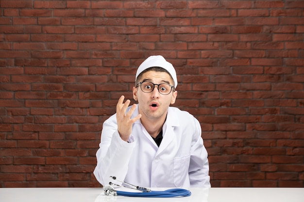 Front view young doctor in white medical suit